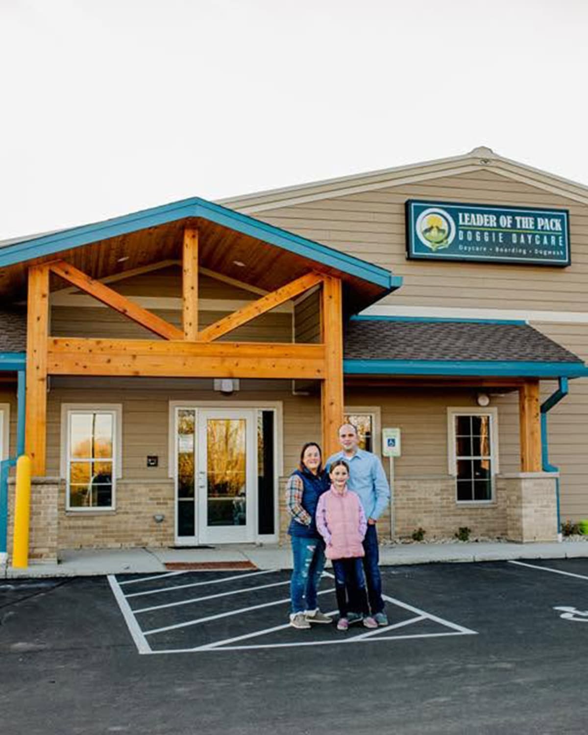 Mary, Ray, and their daughter Emma standing in front of the Leader of the Pack building
